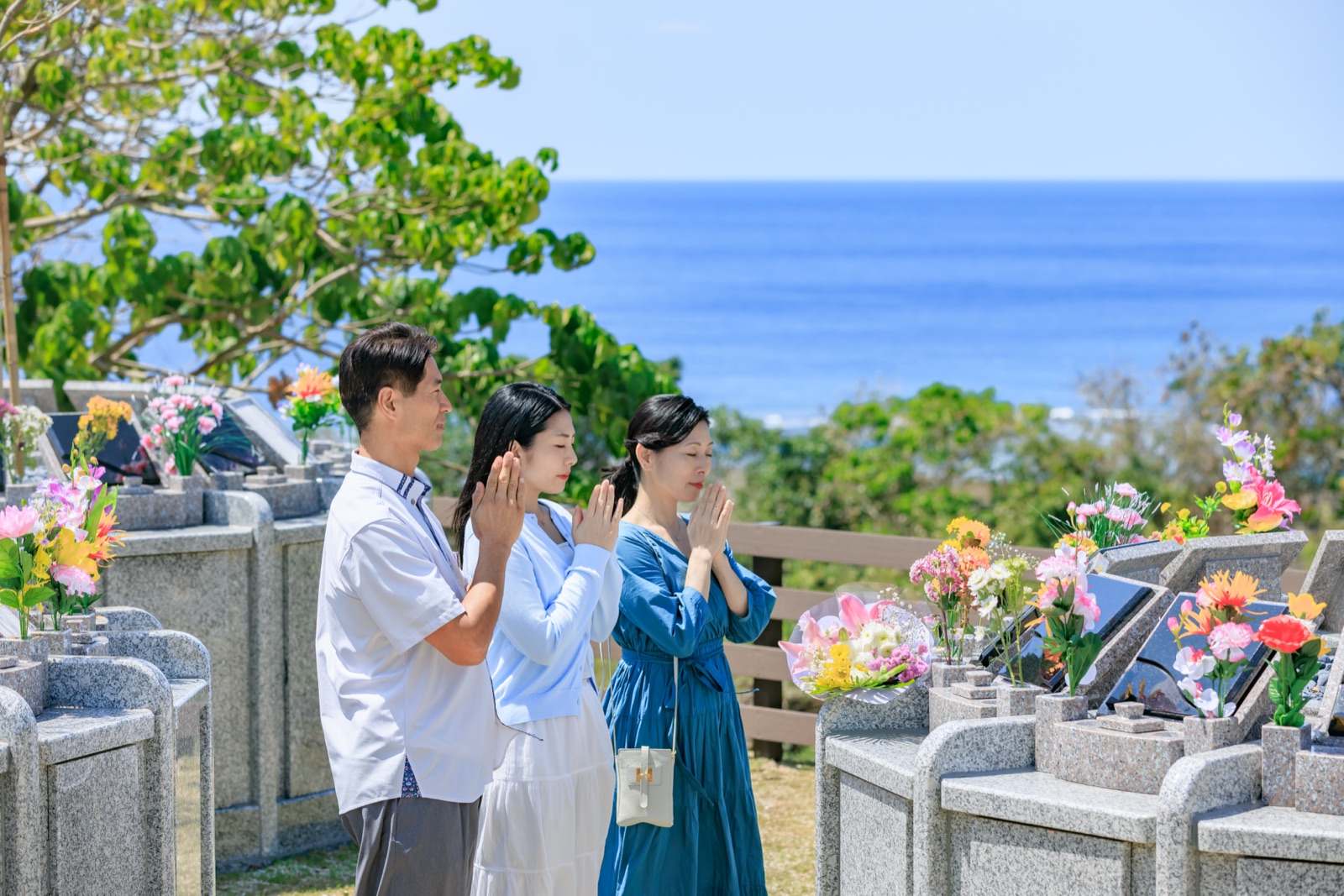 海を背に合掌するご家族